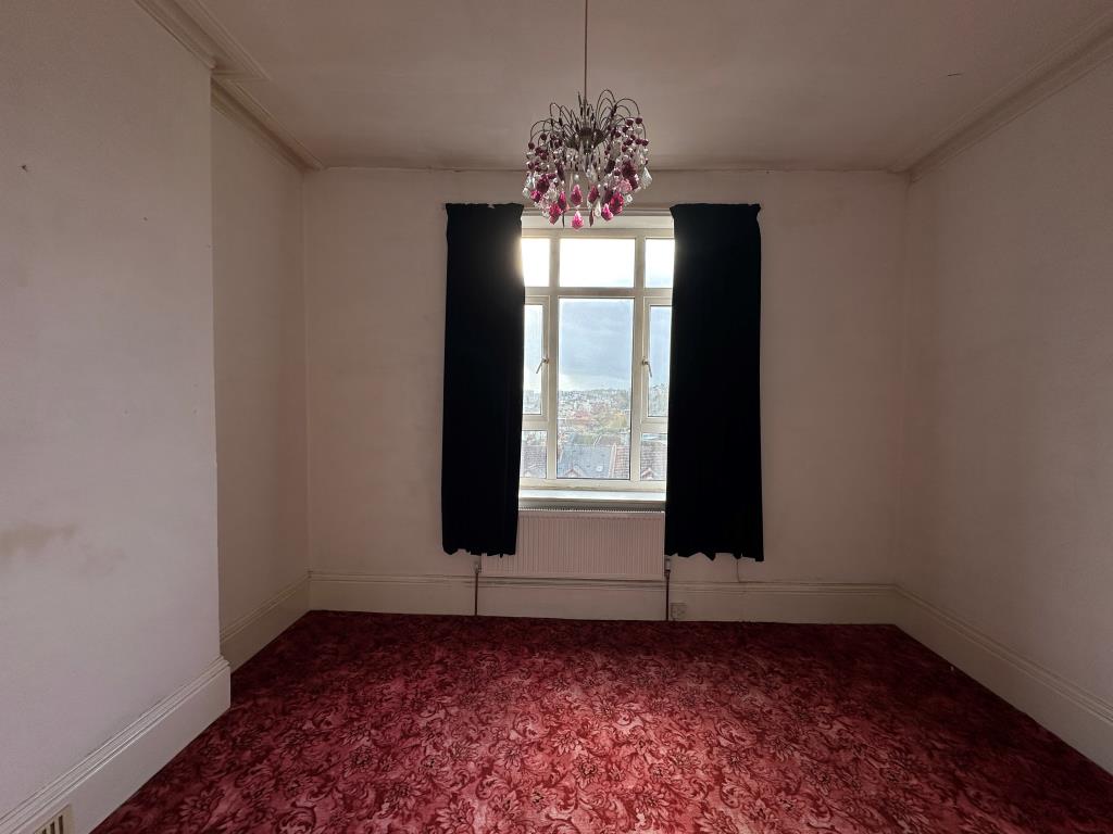 Lot: 81 - TWO-BEDROOM SELF-CONTAINED FLAT FOR IMPROVEMENT - Main bedroom with view from window